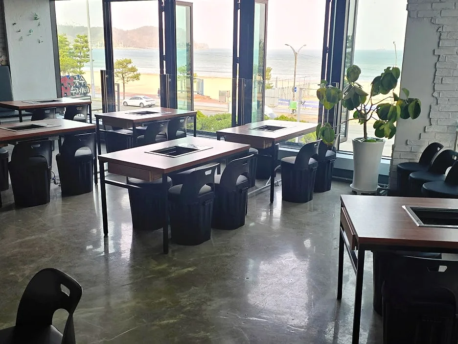 포항 바닷장어 전문점의 바다 전망 홀과 화로 테이블